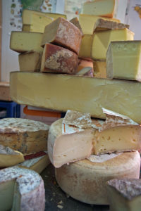 Shop display of various hard cheeses.